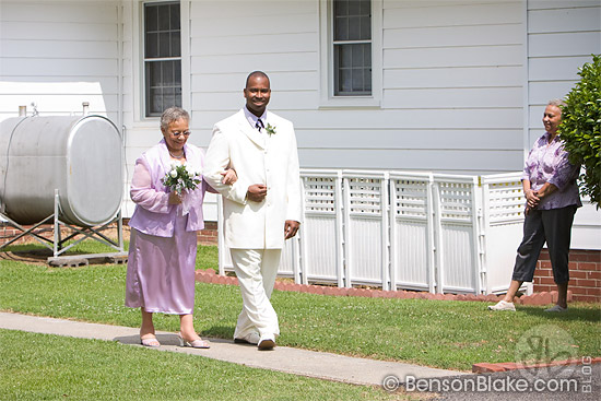 Corrina being escorted by her son, with one of her sisters looking on